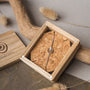 "Opacity Bracelet", a stylish bracelet, featuring walnut and silver elements in a natural wood box.