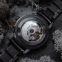 Carbon Wristwatch featuring a dark gray maple finish and intricate mechanical design.