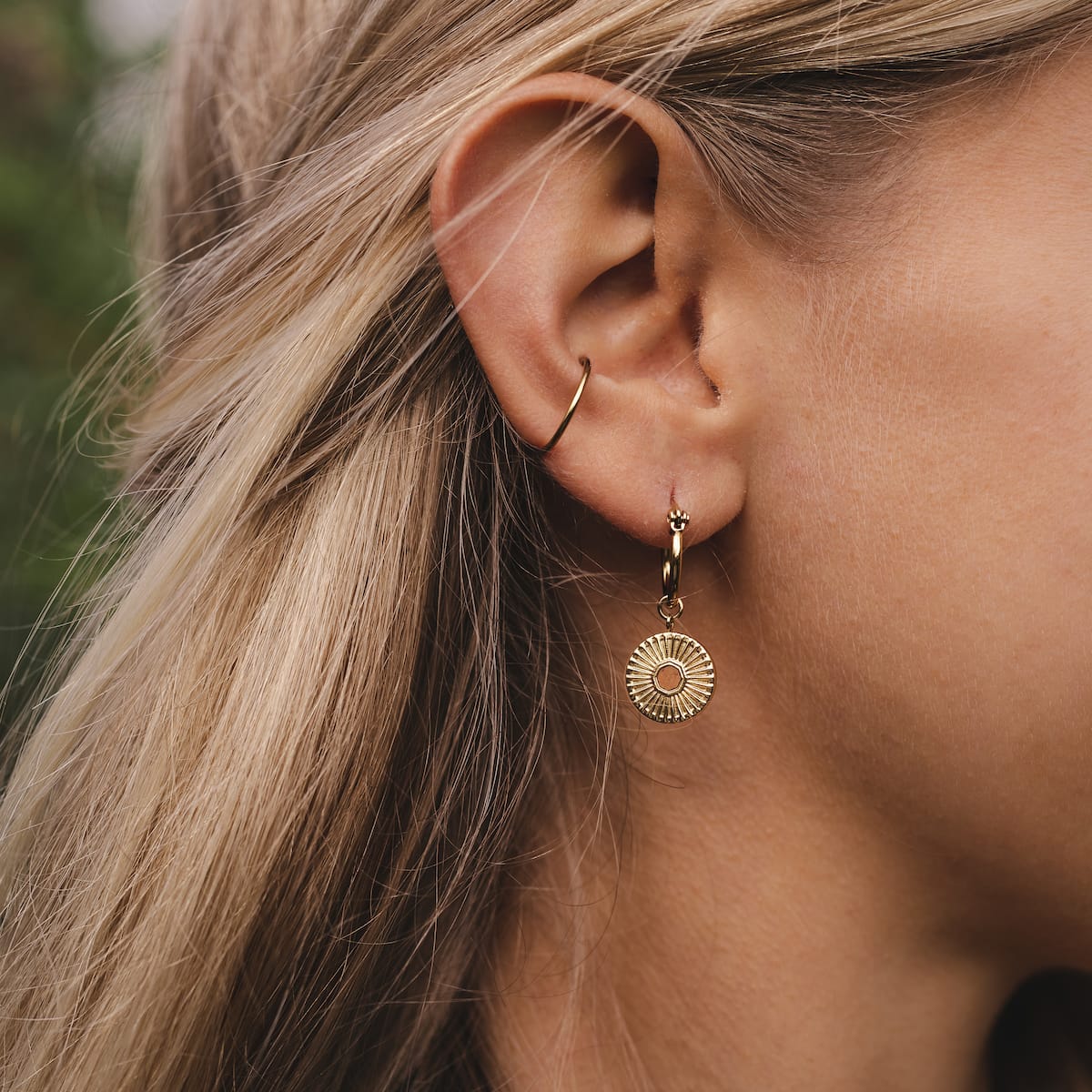 Stencil earrings are elegant earrings featuring a circular gold design with a unique stencil pattern.