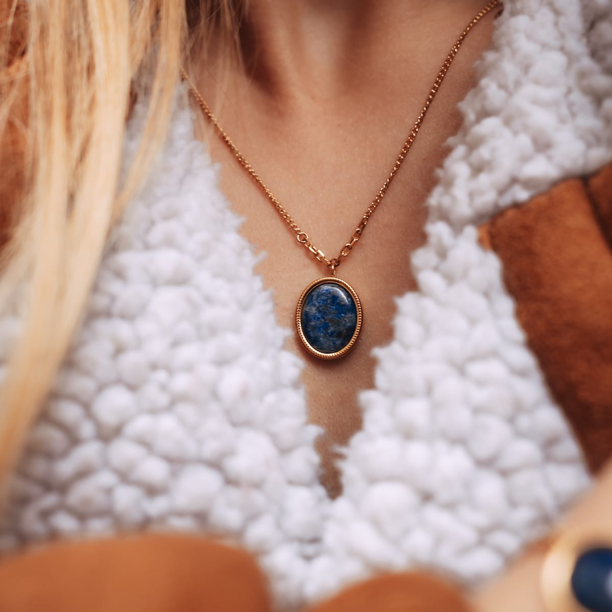 "Mirror Necklace" necklace, featuring Lapis Lazuli in a gold oval setting, brings elegance to a cozy, stylish outfit.