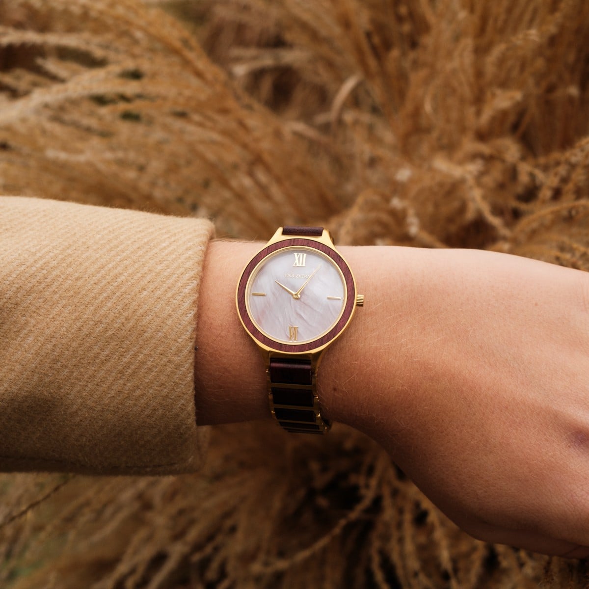 "Mauritius" watch with elegant amaranth and nacre finish, featuring a gold-trimmed face on a wrist.