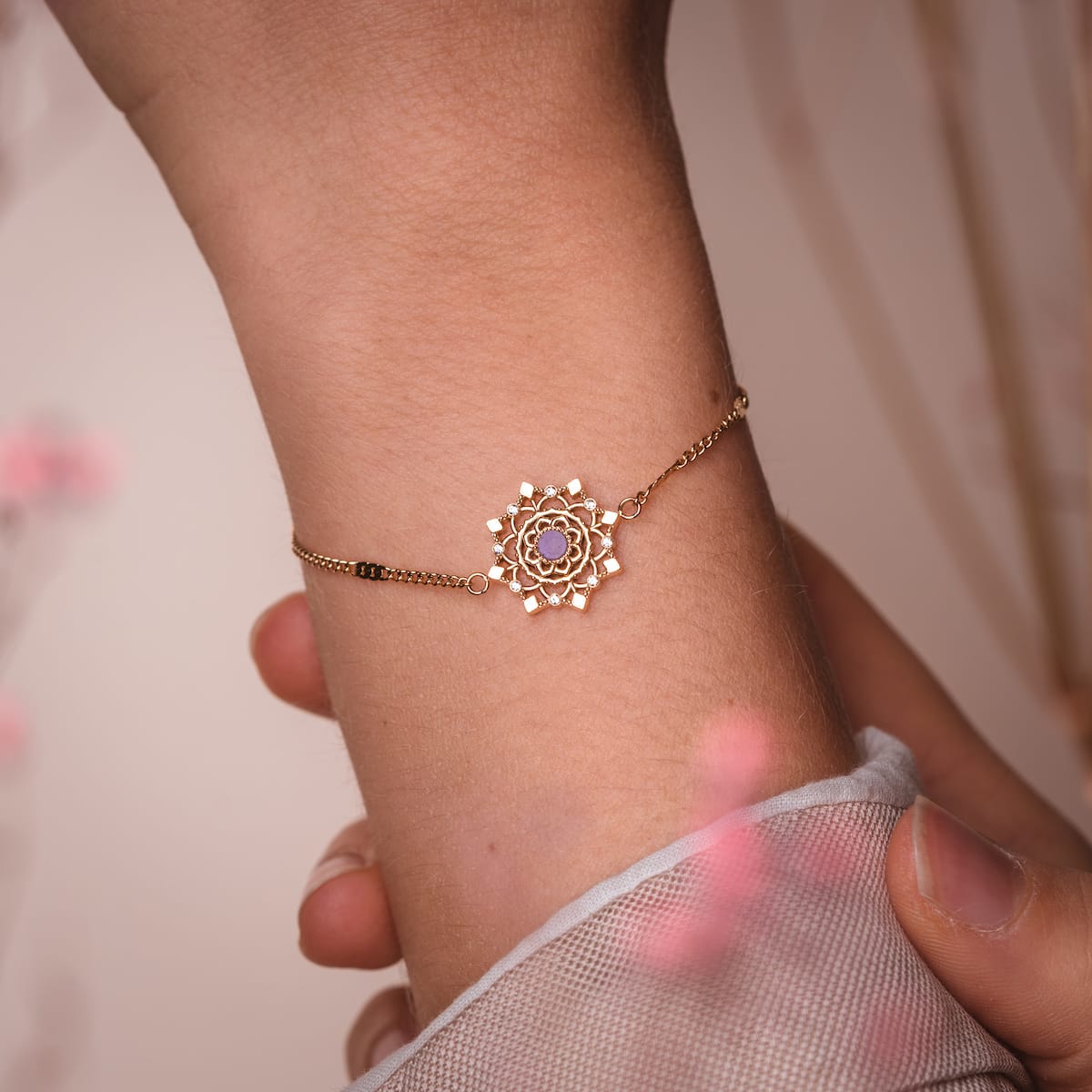 "Aphonia Bracelet", an elegant gold bracelet with amethyst accents, features a delicate, intricate design.