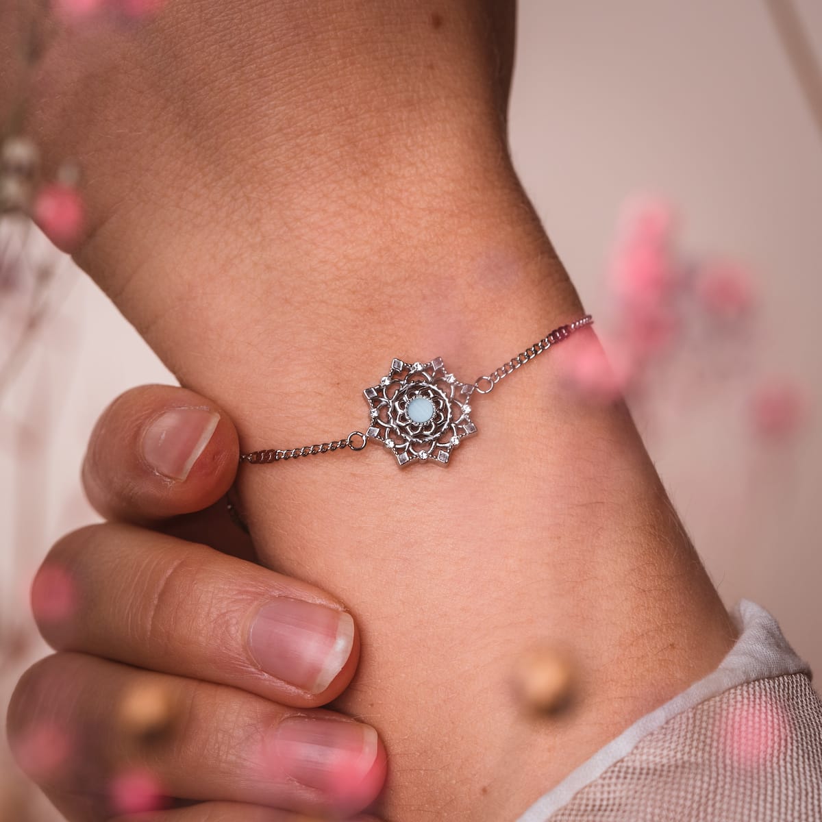 "Aphonia Bracelet" bracelet in aquamarine and silver, featuring an intricate floral design on a delicate wrist.