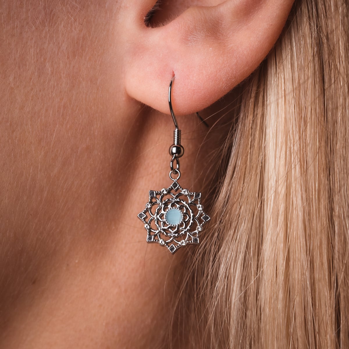 "Aphonia Earrings" earrings in aquamarine and silver with intricate floral design.