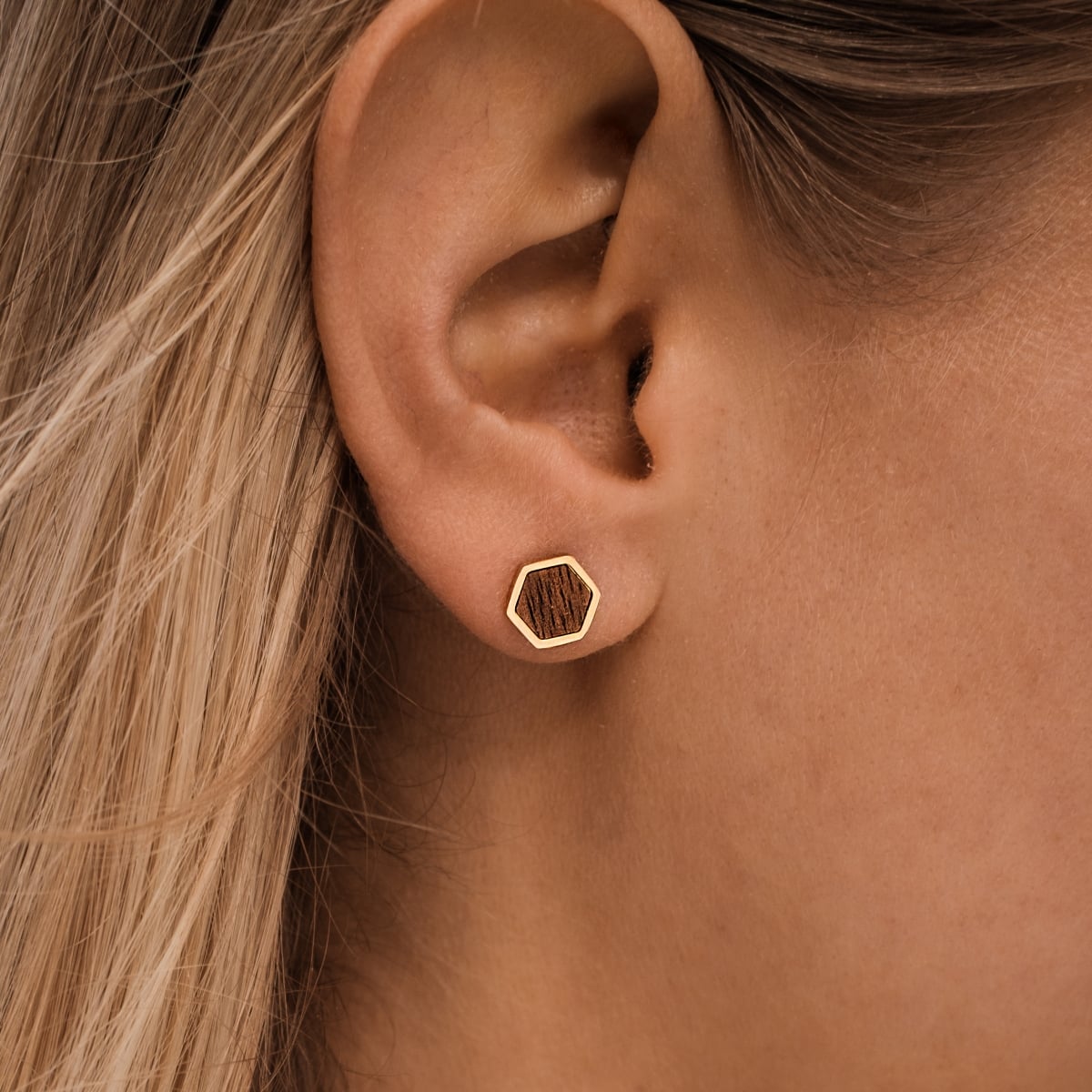 "Facade Earrings" stud earrings in Walnut and gold with a hexagonal design and minimalist style.