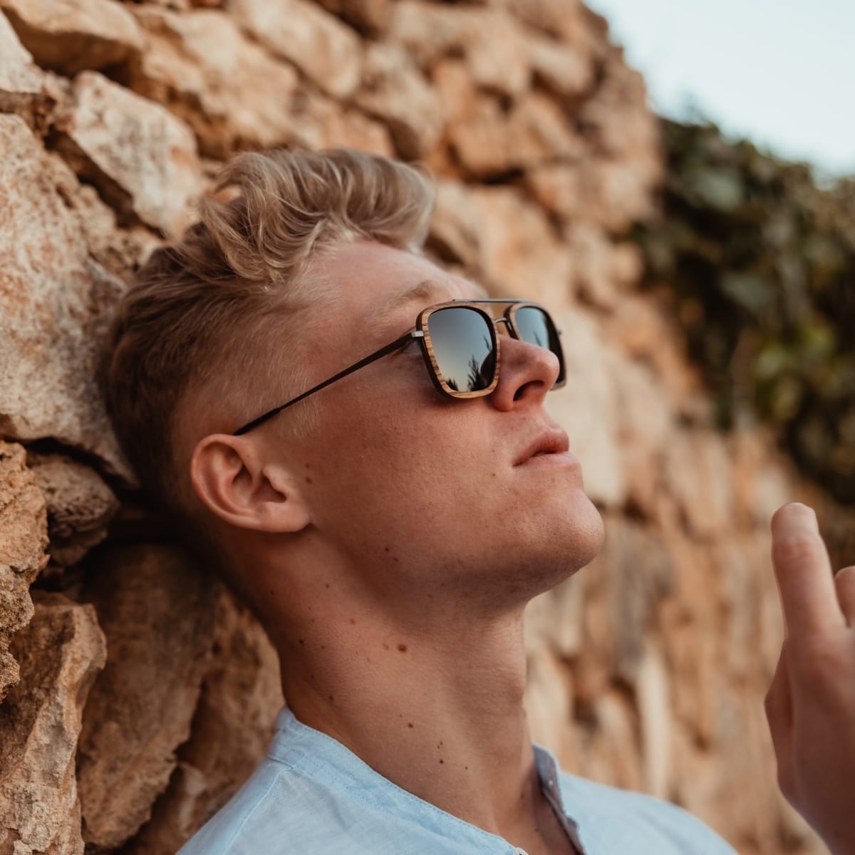 "The Logician" sunglasses, featuring a sleek zebrawood and dark grey design, worn stylishly outdoors.