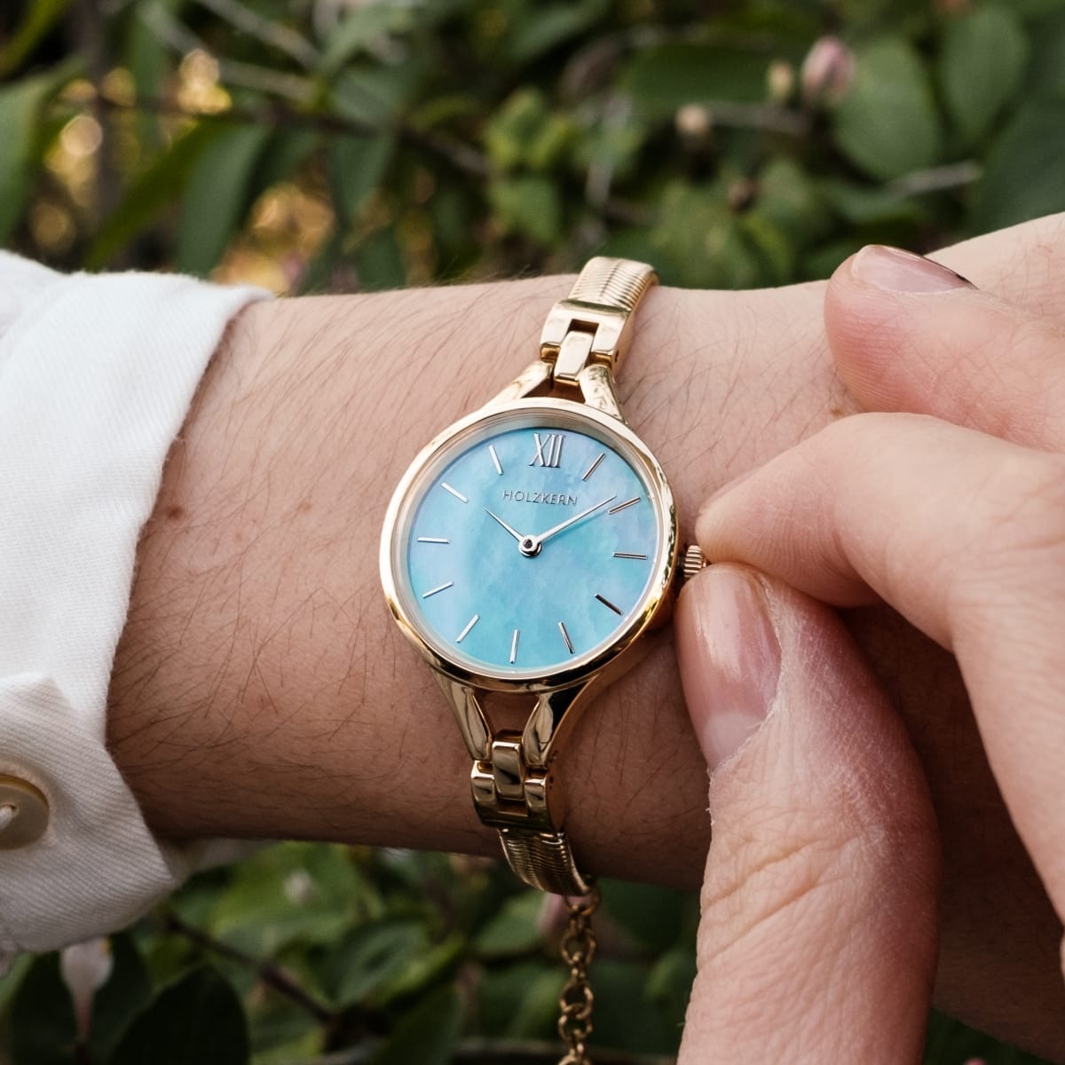 "Shesha" watch featuring a gold-toned design and a blue nacre face, capturing an elegant and timeless style.