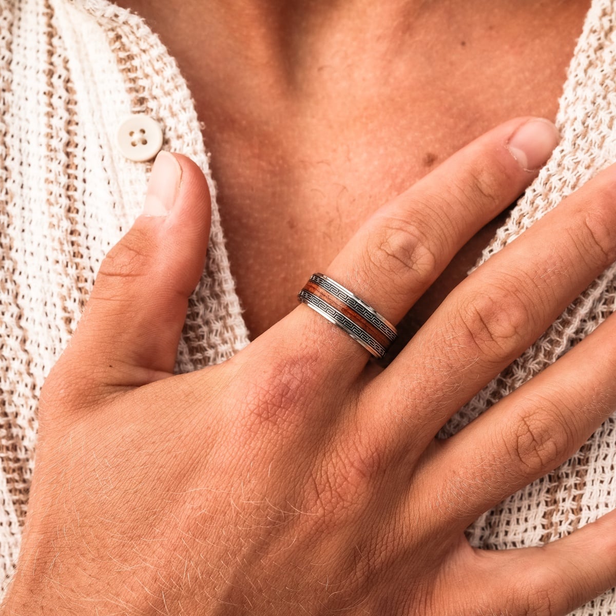 "Numerary Ring", a stylish ring with Koa wood and silver accents, displayed on a hand wearing a textured white fabric.