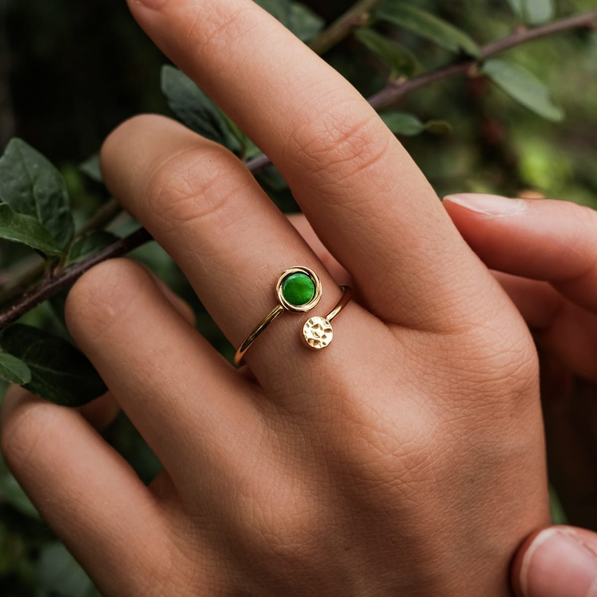 "Zendala Ring", a stylish ring featuring green nacre and gold accents, worn on a hand against a natural background.