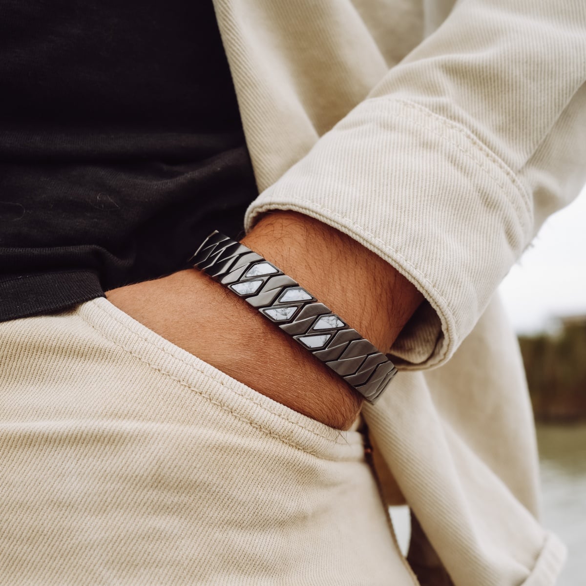 "Baritone" bracelet featuring a sleek dark gray and howlite design, worn in a casual style.