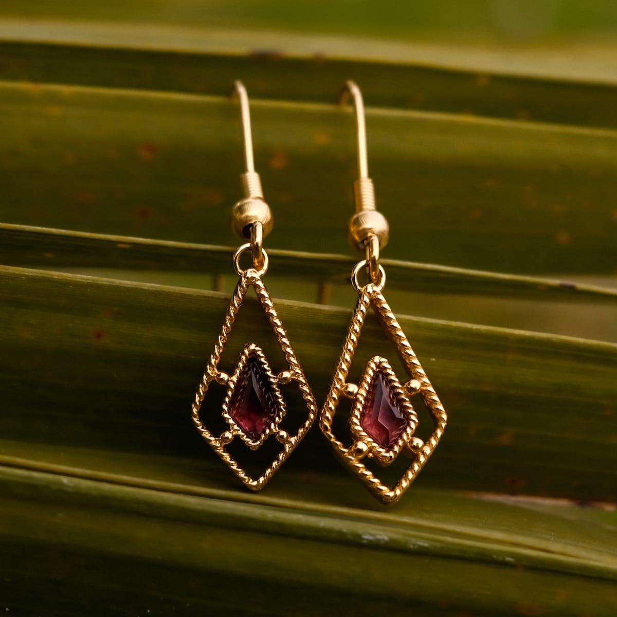 Daydreamer Earrings features elegant earrings with amethyst accents in a gold setting.