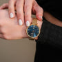 "Giggles" watch with a nacre dial and gold mesh band, offering an elegant and modern style.