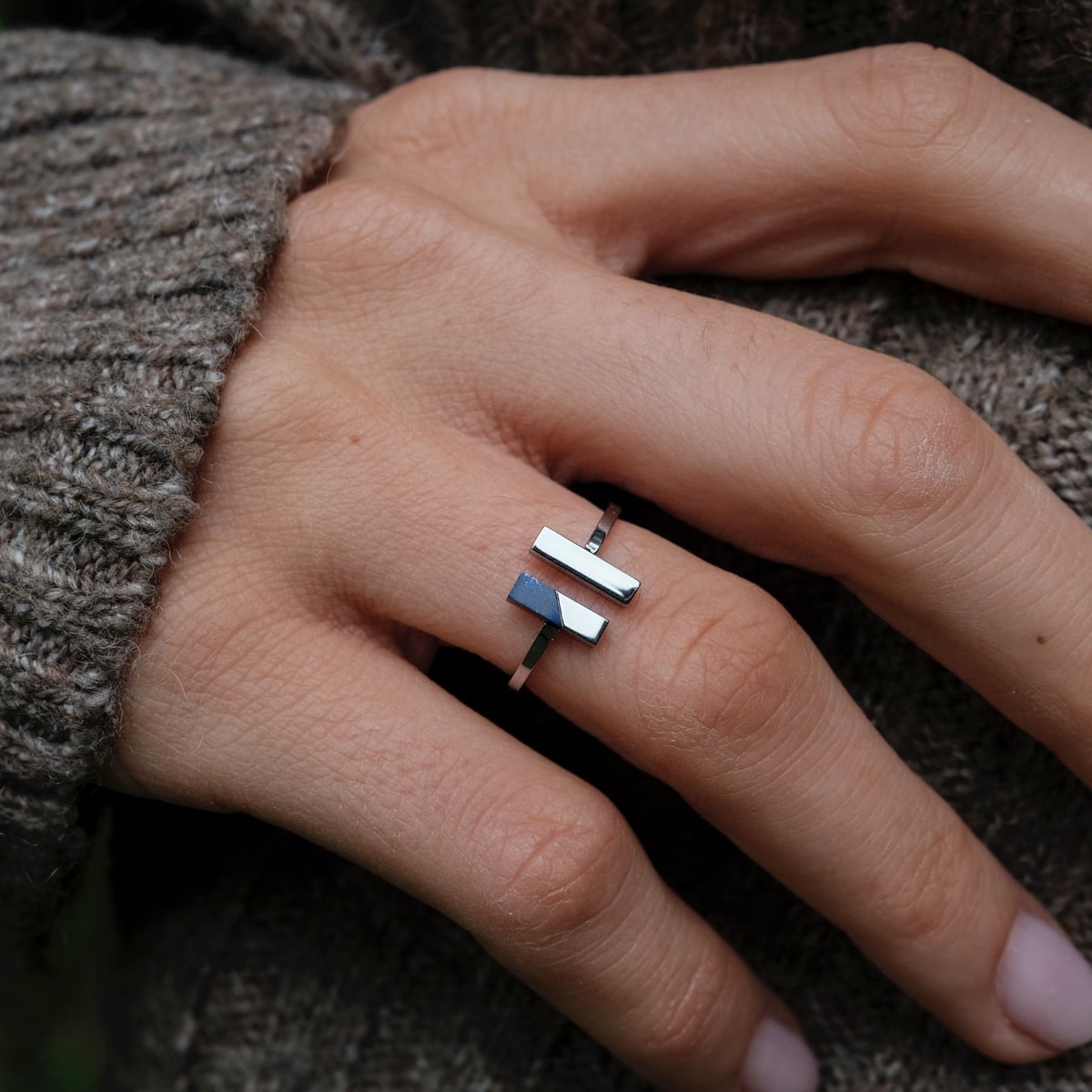 "Campania Ring": Stylish silver ring with lapis lazuli accent, showcased on a hand against a cozy knit backdrop.