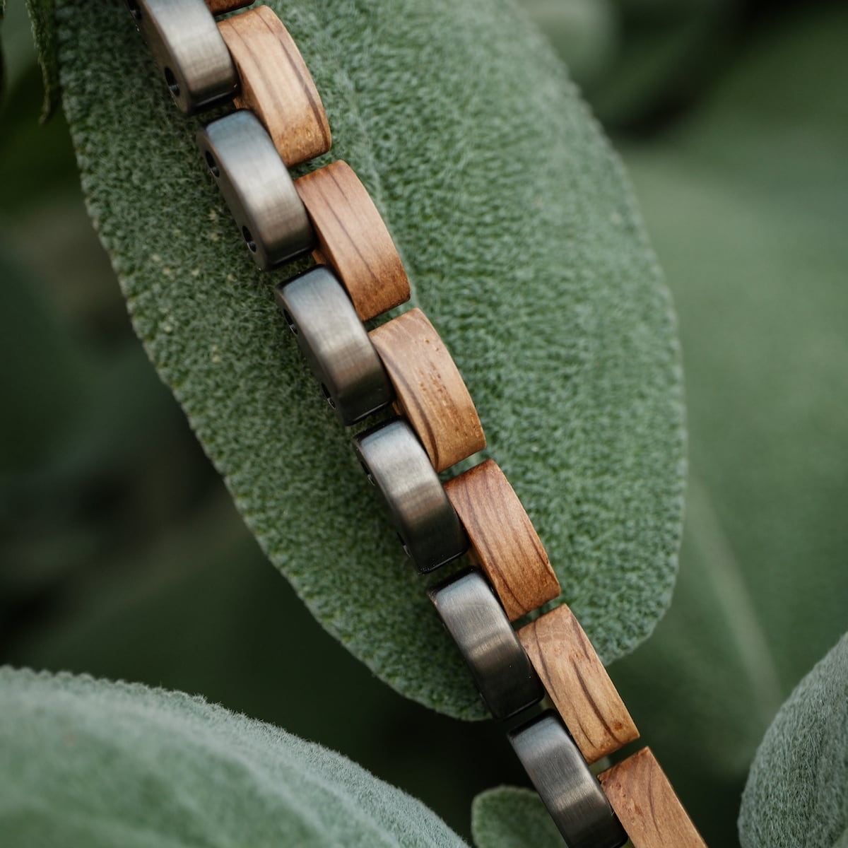 "Duet", an elegant bracelet featuring oak and gray links, set against a natural background.