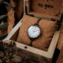 "Touching" wristwatch featuring a nacre dial and antique copper finish, showcased in a rustic wooden box.