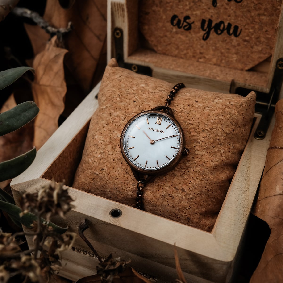"Touching" wristwatch featuring a nacre dial and antique copper finish, showcased in a rustic wooden box.