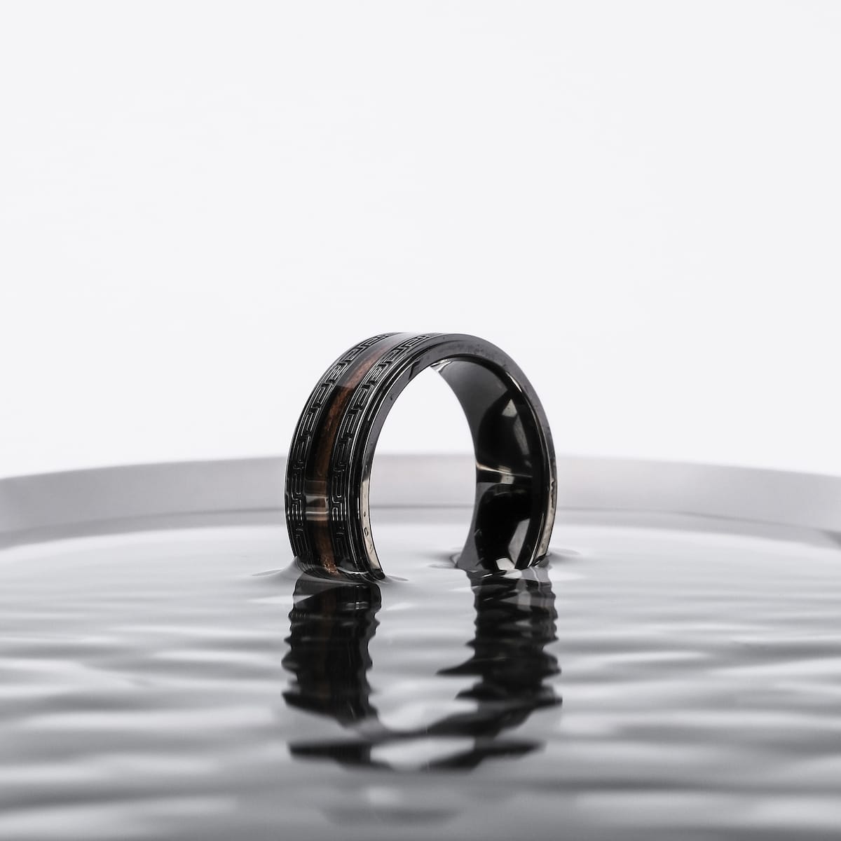"Numerary Ring", a stylish walnut and gray ring, showcased with a sleek, modern aesthetic.