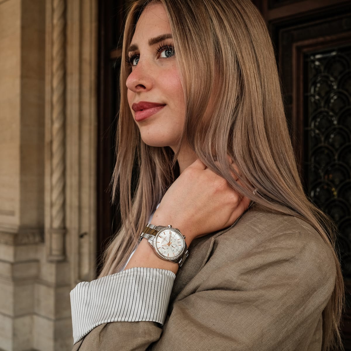 "The Balanced" watch, featuring a nacre and silver design, worn by a woman with a classic, elegant style.