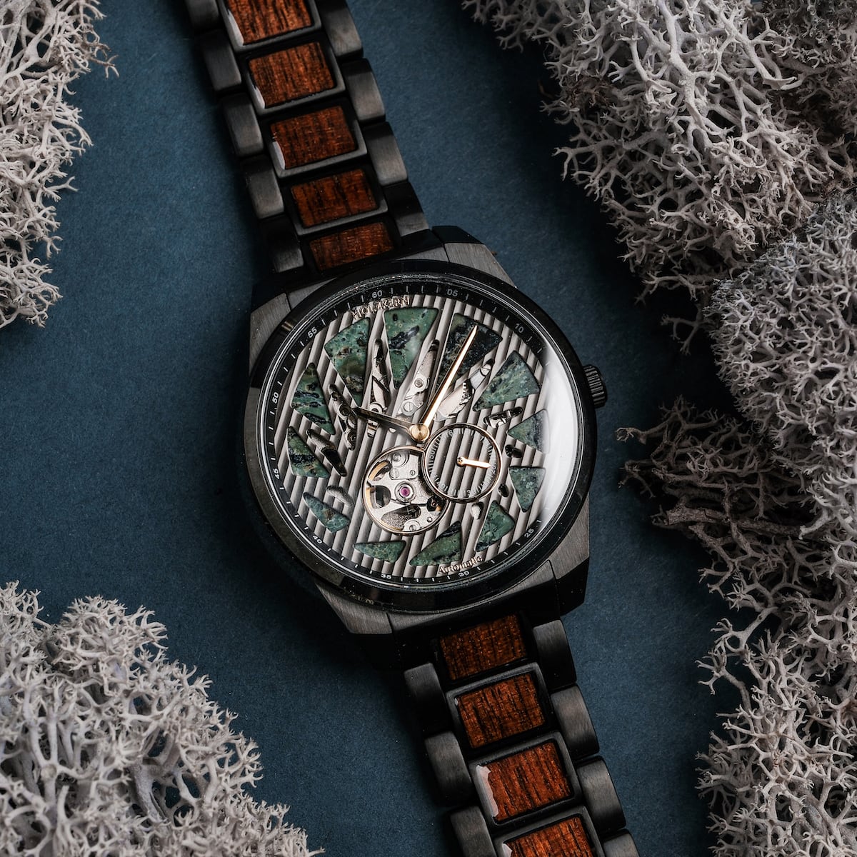 "Adrenin watch featuring a stylish Cat's Eye face and Walnut accents, surrounded by decorative moss."