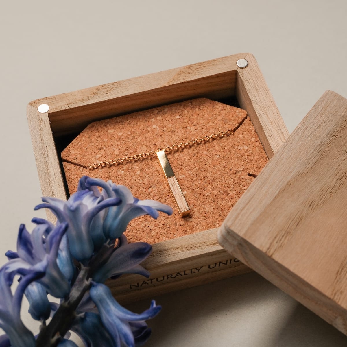 "Campania Necklace" necklace with koa wood and gold accents in an elegant wooden display box.