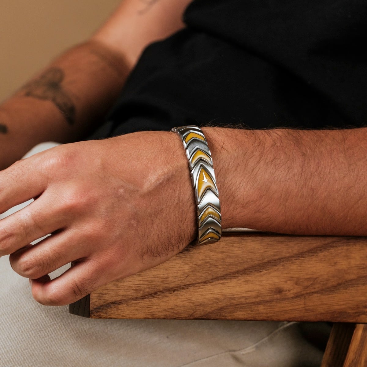 "Command" bracelet featuring a jade and silver chevron design, worn casually on a wrist.