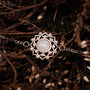 "Composition Gem Bracelet" — Elegant bracelet featuring a moonstone centerpiece with rose gold accents, styled against a natural backdrop.