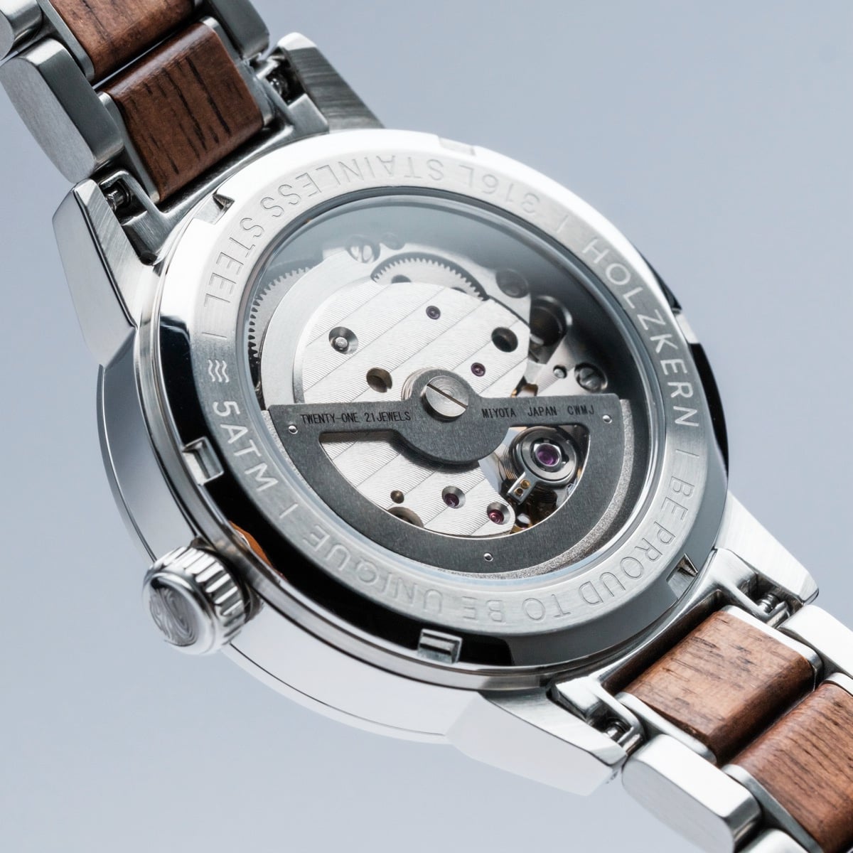 "Colorburst" watch showcases a stainless steel casing with walnut accents, featuring intricate mechanical details.