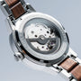 "Colorburst" watch showcases a stainless steel casing with walnut accents, featuring intricate mechanical details.