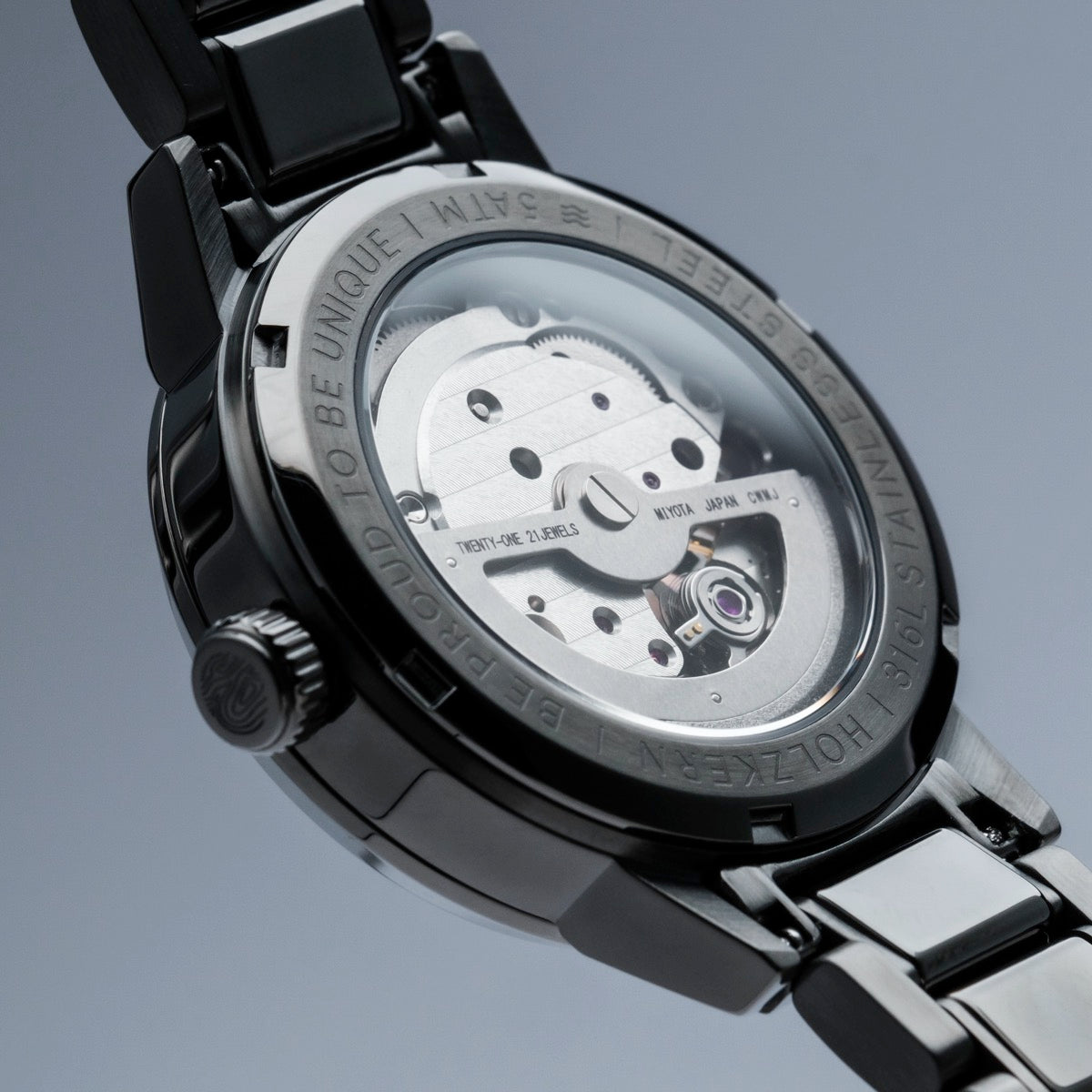 "Mirrordance", a sleek watch with a nacre-ceramic finish and intricate rear mechanism, showcasing modern elegance and craftsmanship.