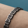 "Adagio", a sleek bracelet featuring a maple and silver design, elegantly displayed on a neutral fabric.