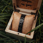 "Baritone" bracelet in stylish dark grey with maple accents, elegantly displayed in a wooden box on textured fabric.