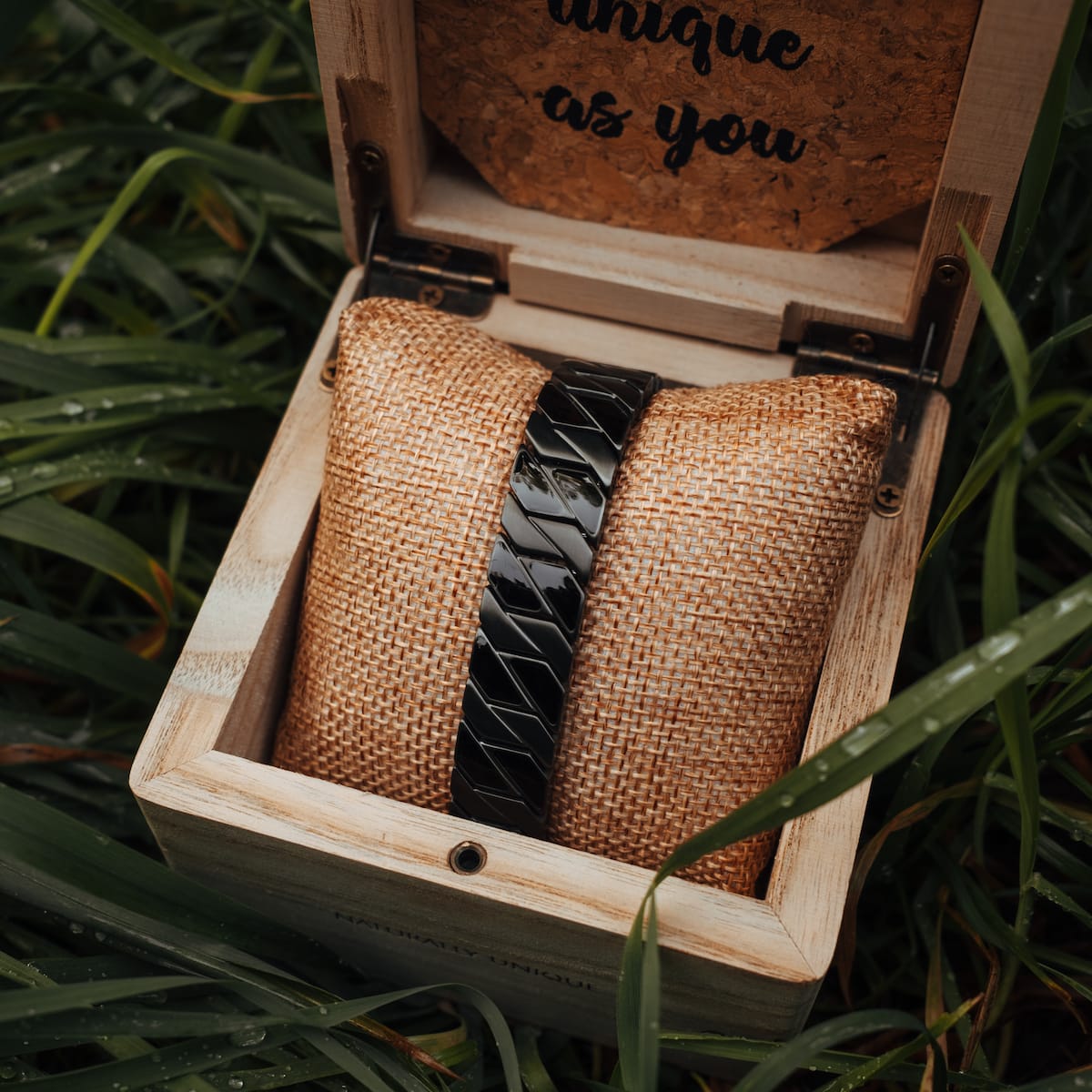"Baritone" bracelet in stylish dark grey with maple accents, elegantly displayed in a wooden box on textured fabric.