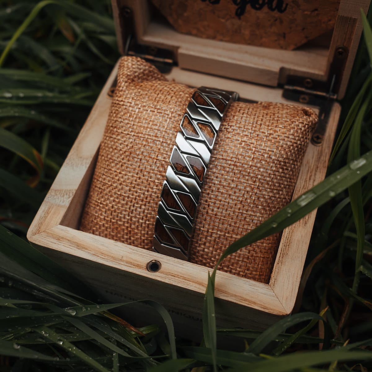 "Baritone" bracelet in Walnut and silver, displayed in a rustic wooden box with a natural setting.