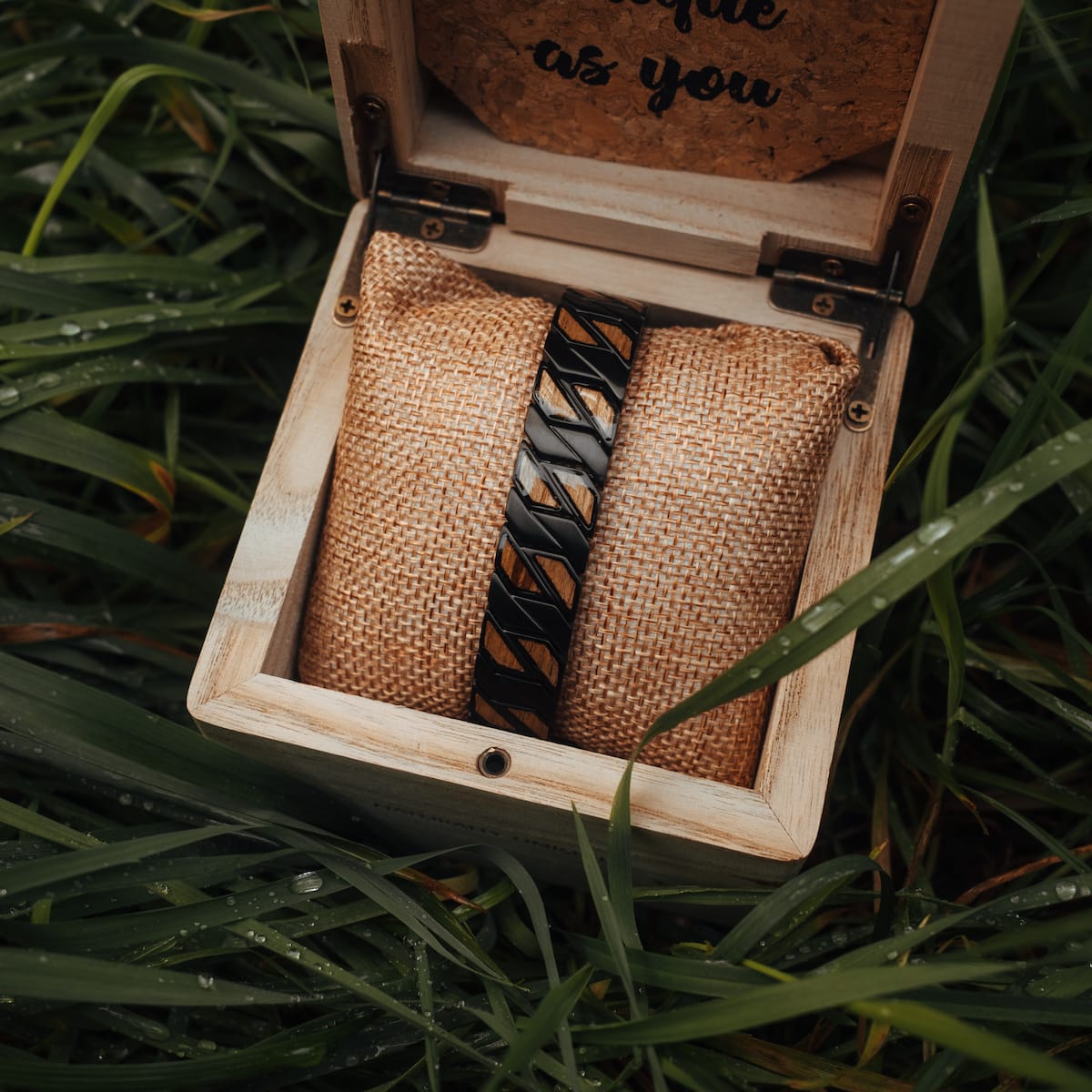 "Baritone", a stylish bracelet crafted with zebrawood and black accents, presented in a rustic wooden box.