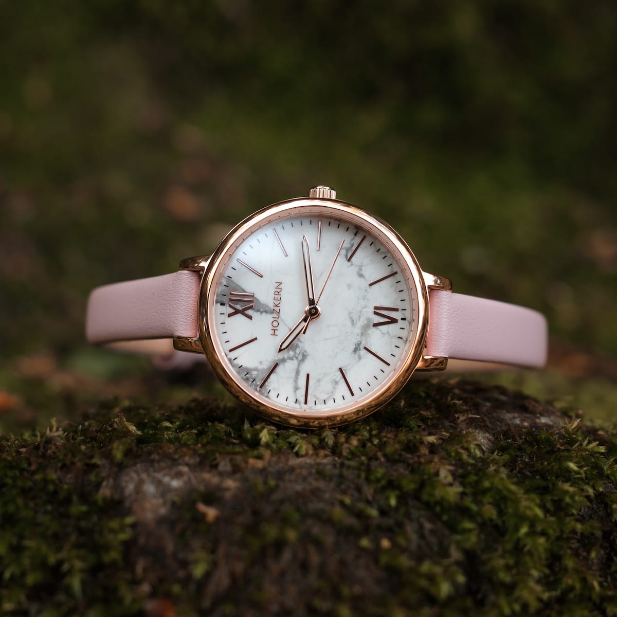 "Alva" watch featuring a marble face and rose gold accents with a pink strap.