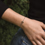 "Opacity Bracelet", a delicate bracelet featuring walnut and silver, elegantly styled on a wrist.