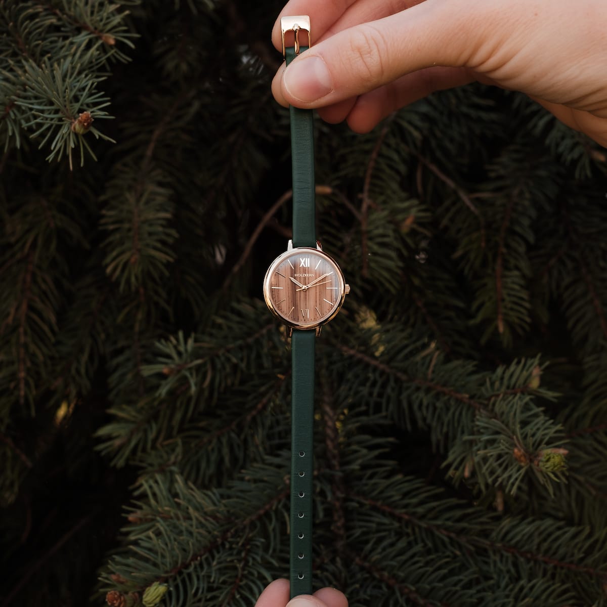 "Wangari" watch features a stylish zebrawood face with gold accents, complemented by a green strap.