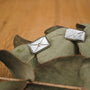 "Aquarell Earrings" earrings with a white nacre and silver design, displayed on greenery.
