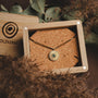 "Stencil Necklace" necklace with a marble and gold design, elegantly displayed in a wooden box.