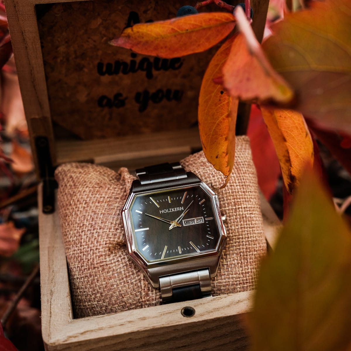 "Kéré" watch with maple accents, displayed in a rustic wooden box with autumn leaves.