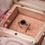 "Facade Ring" - a sleek hexagonal ring in marble and silver, set in a wooden box with a rustic aesthetic.