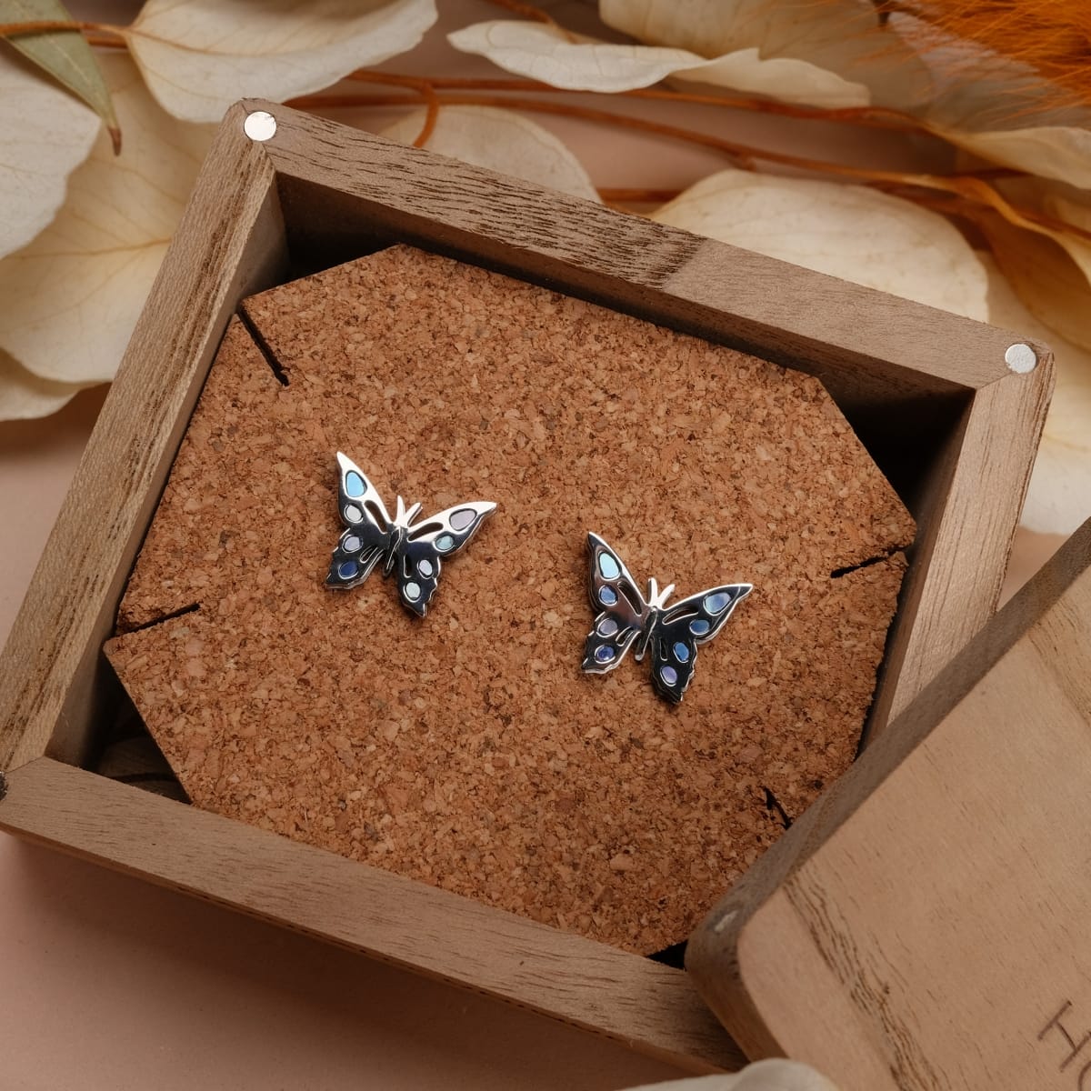 "Fritillary Earrings" butterfly earrings in nacre and silver, featuring a delicate and artistic design in a cork-lined wooden box.