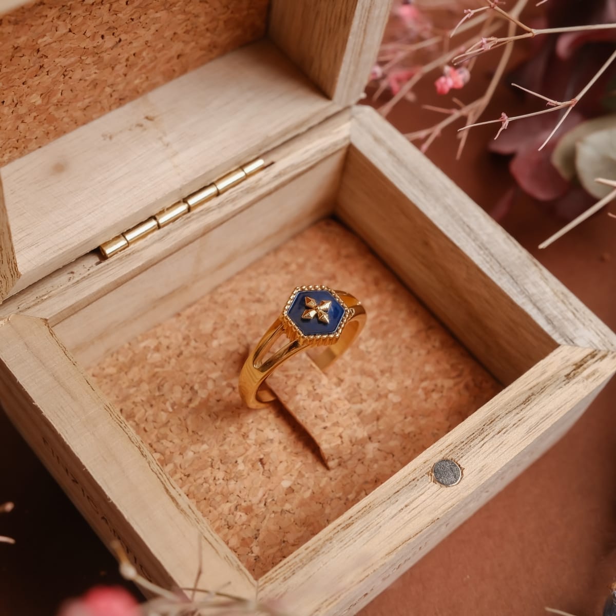"Spectral Ring" - Elegant gold ring with blue nacre detail, showcased in a wooden box.