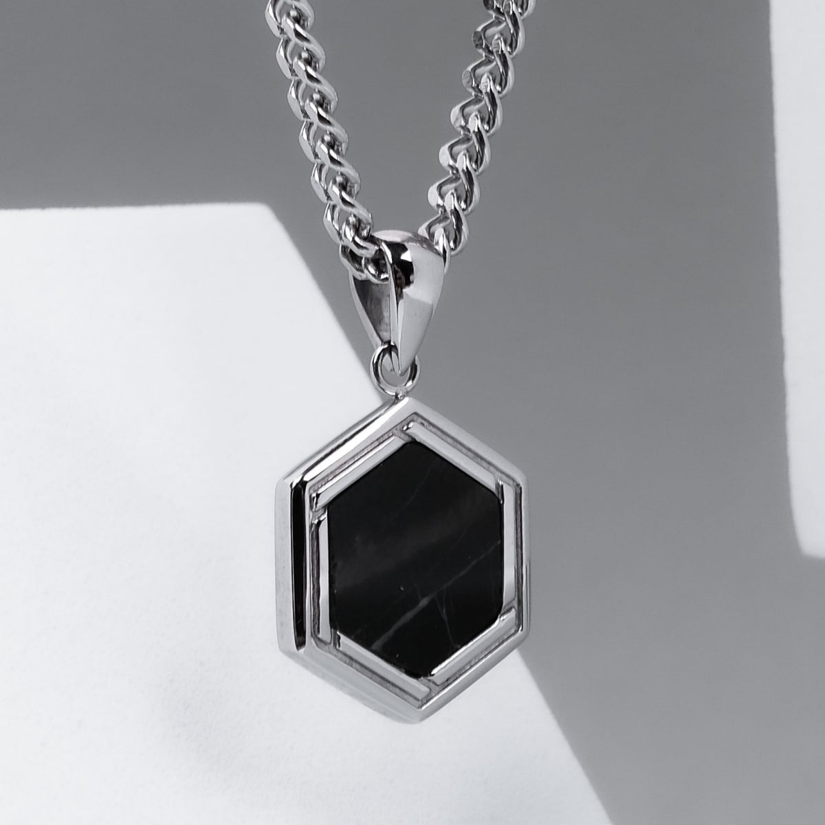 "Axis Necklace", a hexagonal marble and silver necklace with a sleek, modern design.