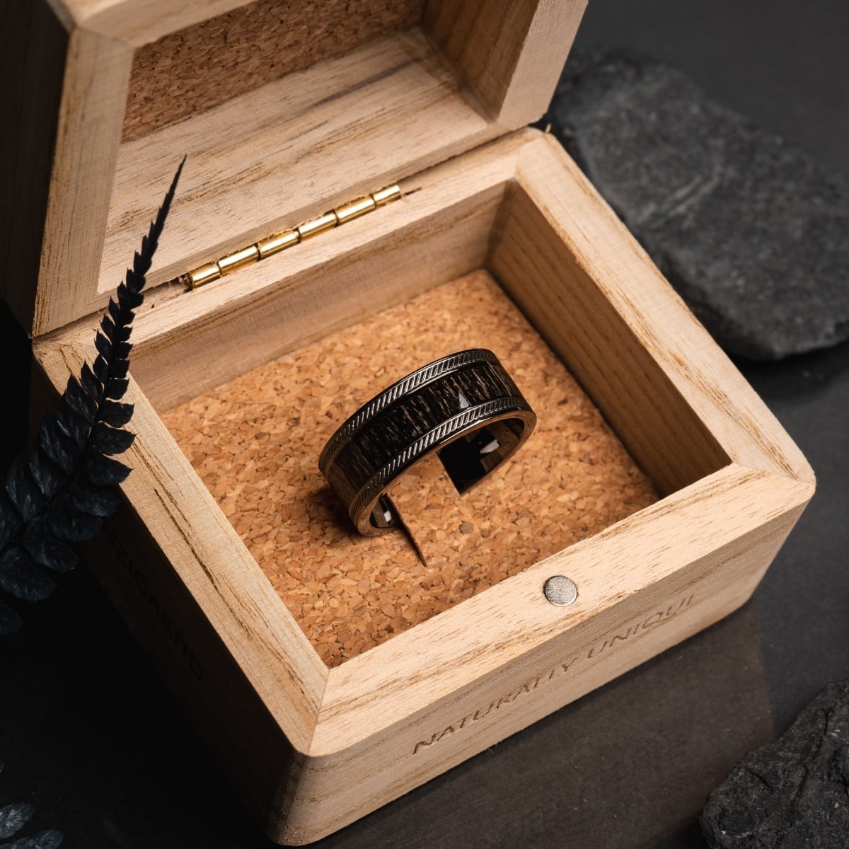 "Countless Ring", a stylish ring made of maple and dark gray material, elegantly displayed in a wooden box.