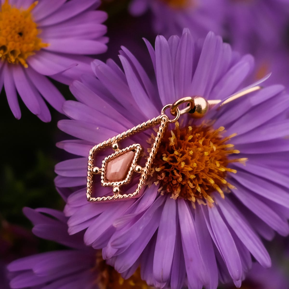 "Daydreamer Earrings" earrings feature a rose quartz gemstone set in rose gold with a delicate, geometric design.