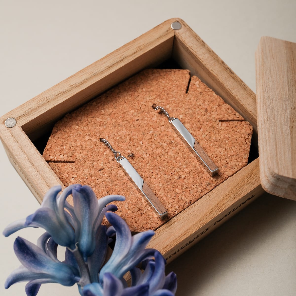 "Campania Earrings" earrings in Walnut and Silver, showcasing a modern, minimalist design in a wooden box.