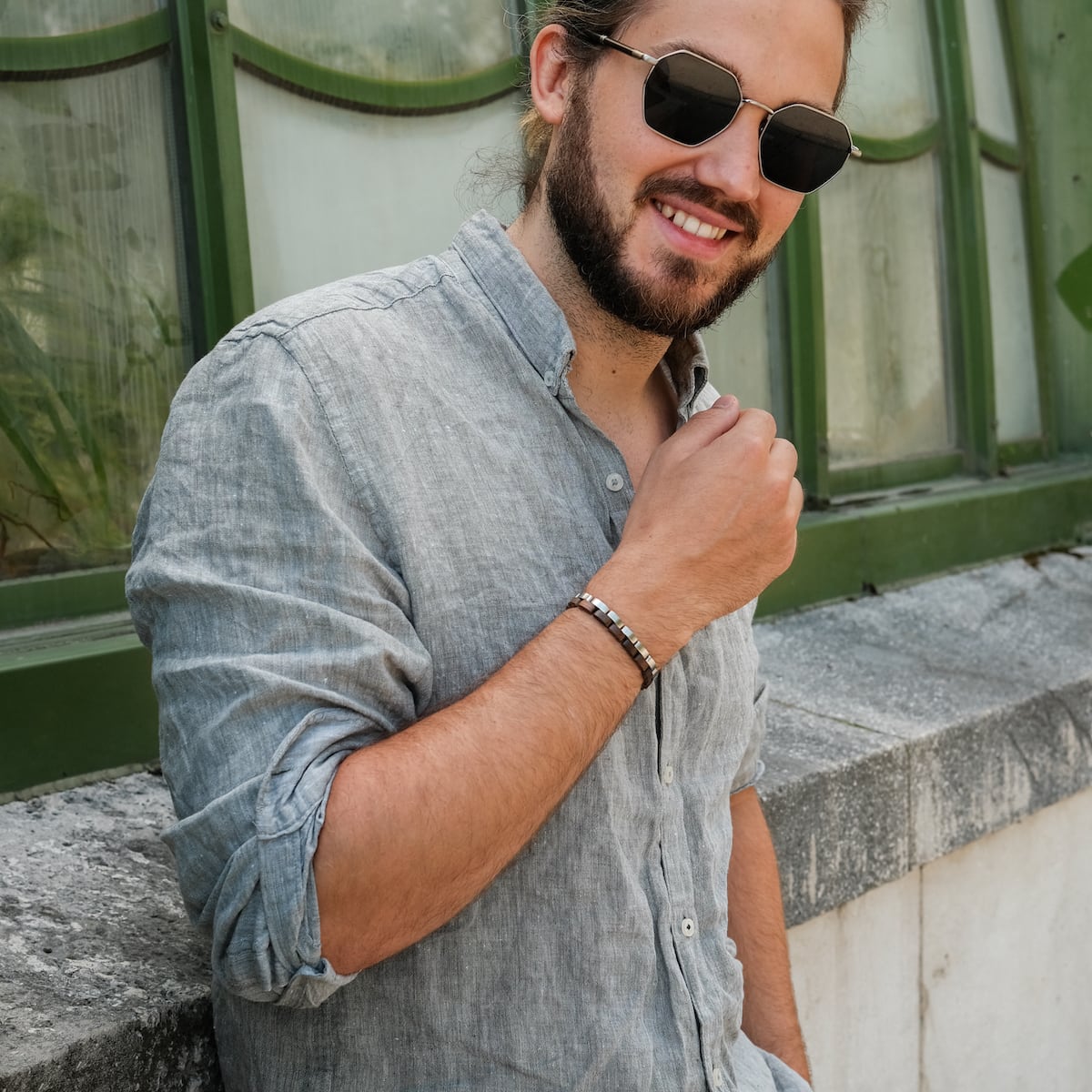 "Duet" bracelet in walnut and silver, featuring a sleek, modern design worn by a casually styled individual outdoors.