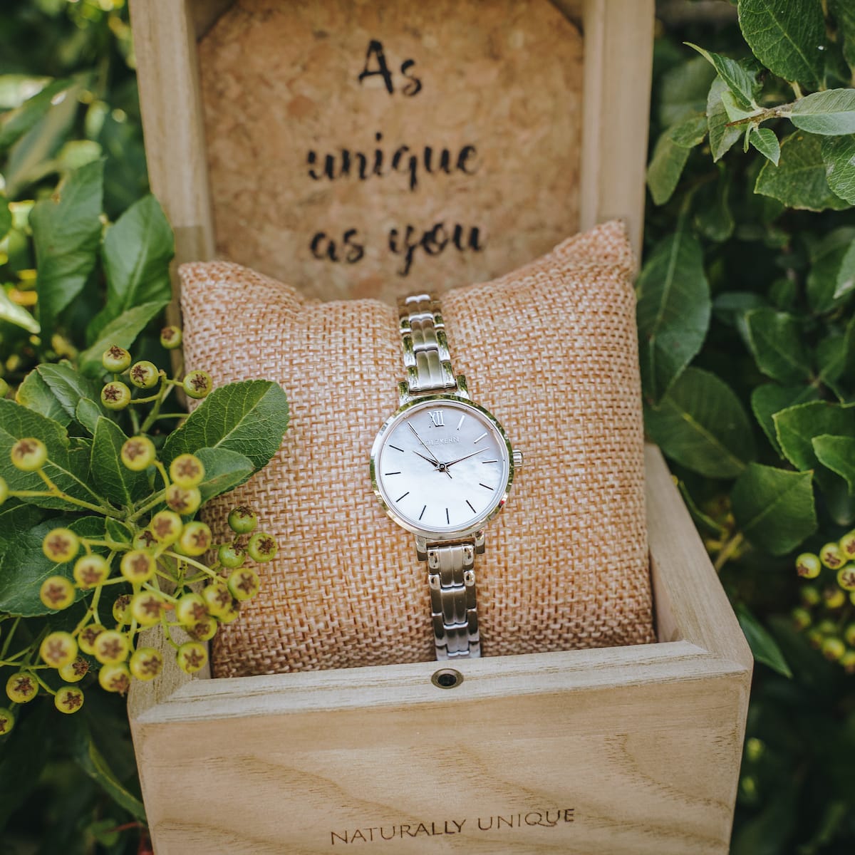 "Skadi", a stylish watch with nacre and silver elements, elegantly displayed in a natural setting.