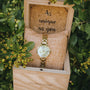 "Themis" watch featuring a nacre dial and gold bracelet, styled elegantly in a natural setting.